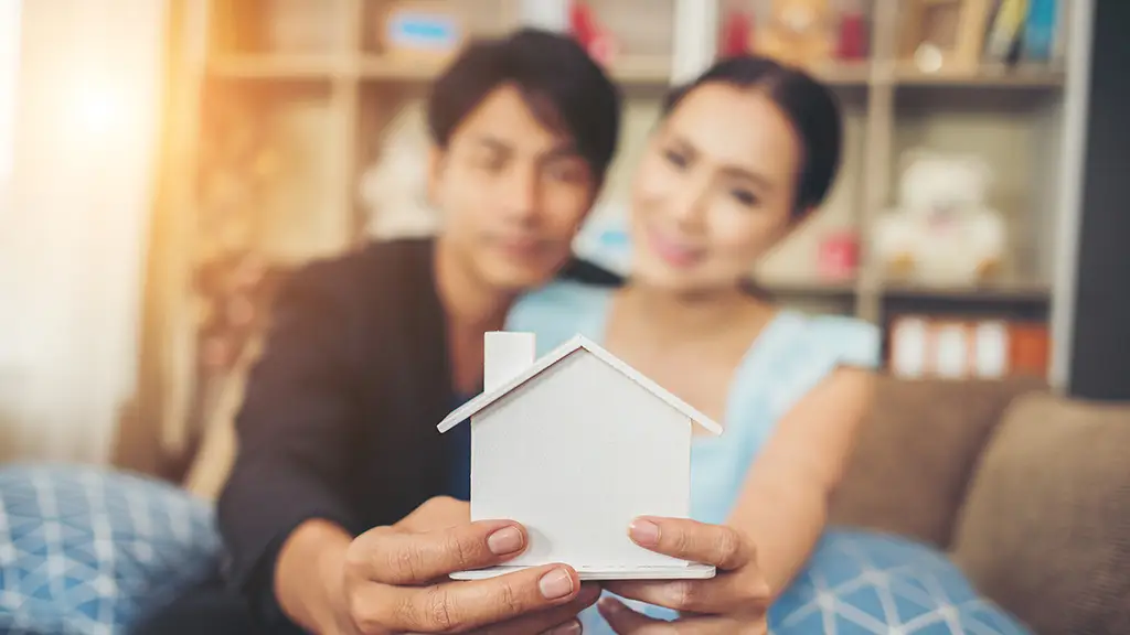 Couple holding a small white model house